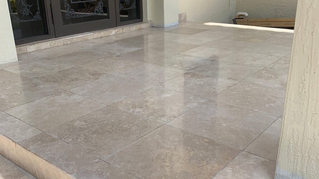 Beige polished limestone floor in front of a brown door landing.
