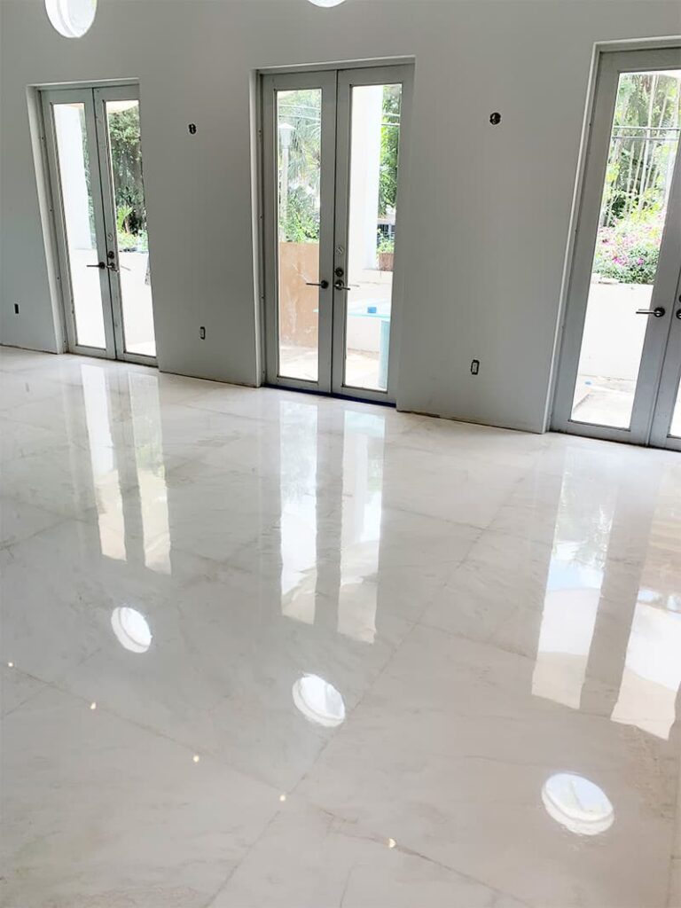 Shiny white marble floor with three glass doors.